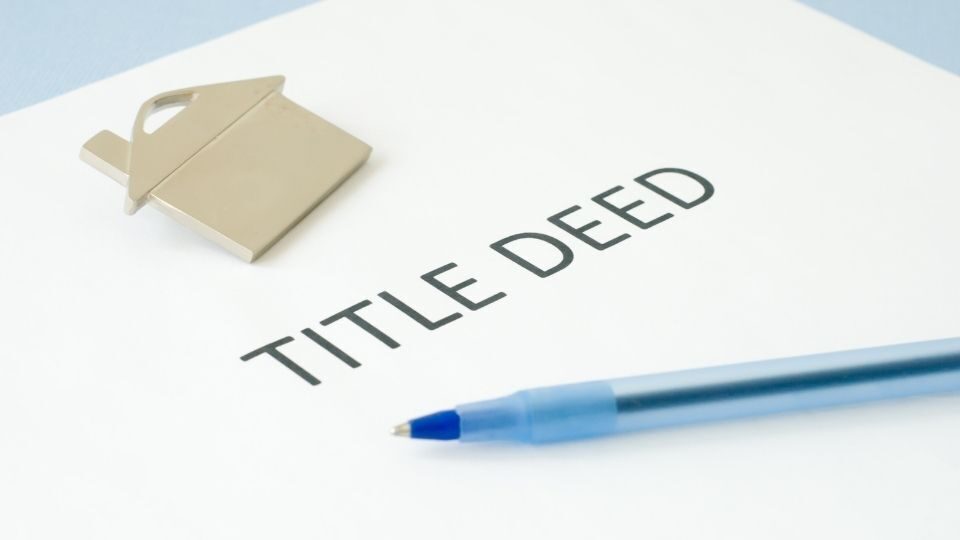 (In the image it can be seen a paper is there having title deed written along with a property symbol) What Do Property Title Deeds UK Look Like