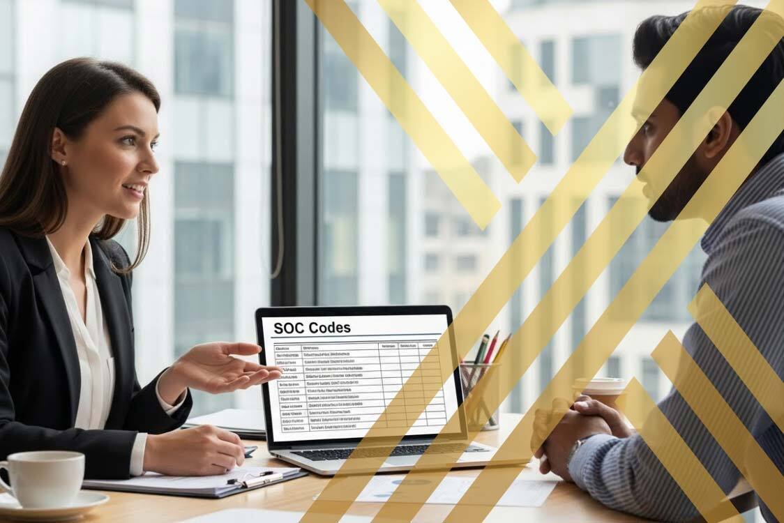 An HR manager explaining visa options to an international employee at a desk, showing SOC codes on a laptop screen.
