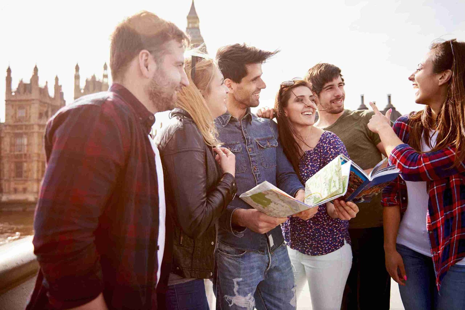 A group of young people gathered around a map, discussing their route with enthusiasm and curiosity.