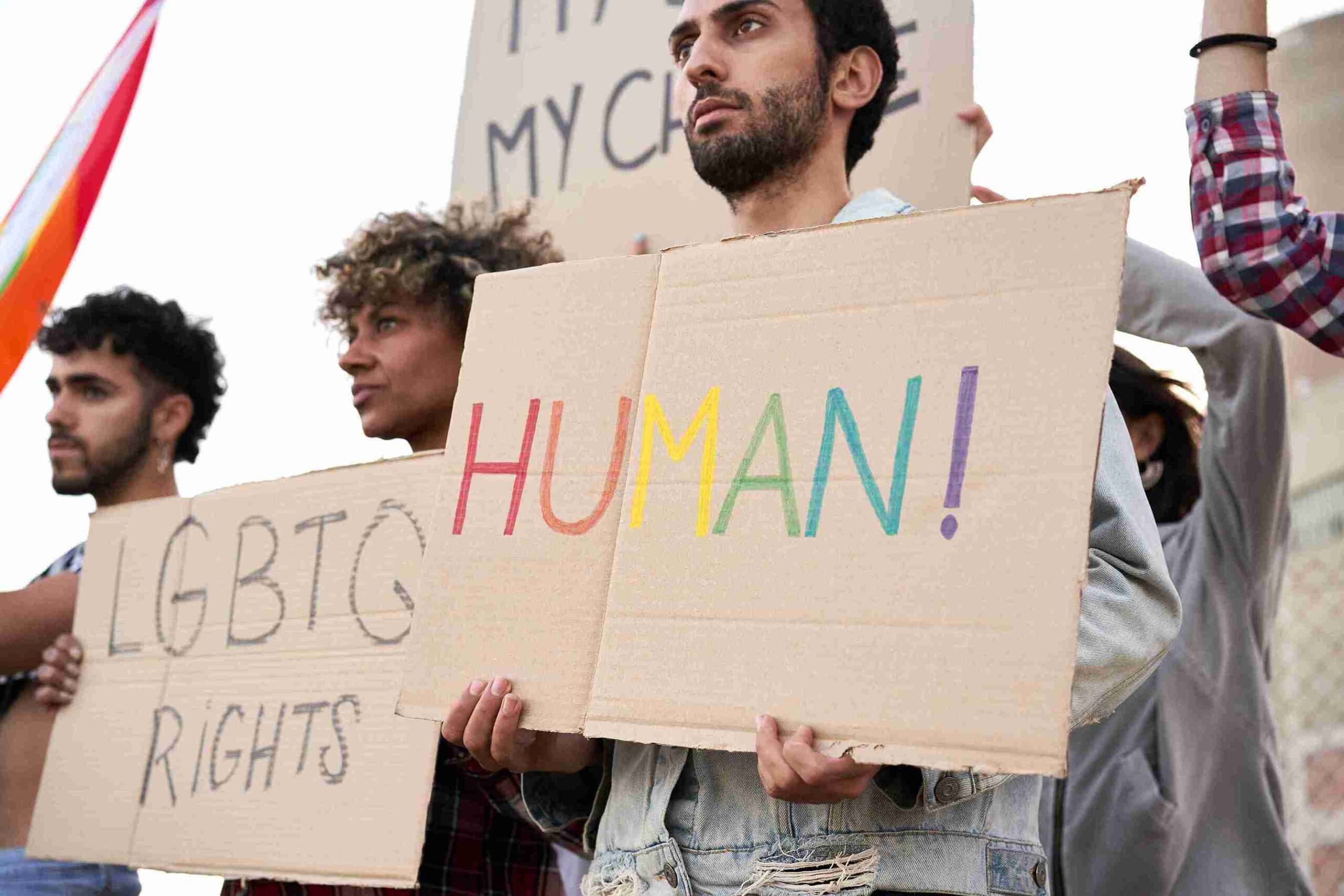 A diverse group of people holding signs advocating for LGBT human rights, emphasizing support for human rights.