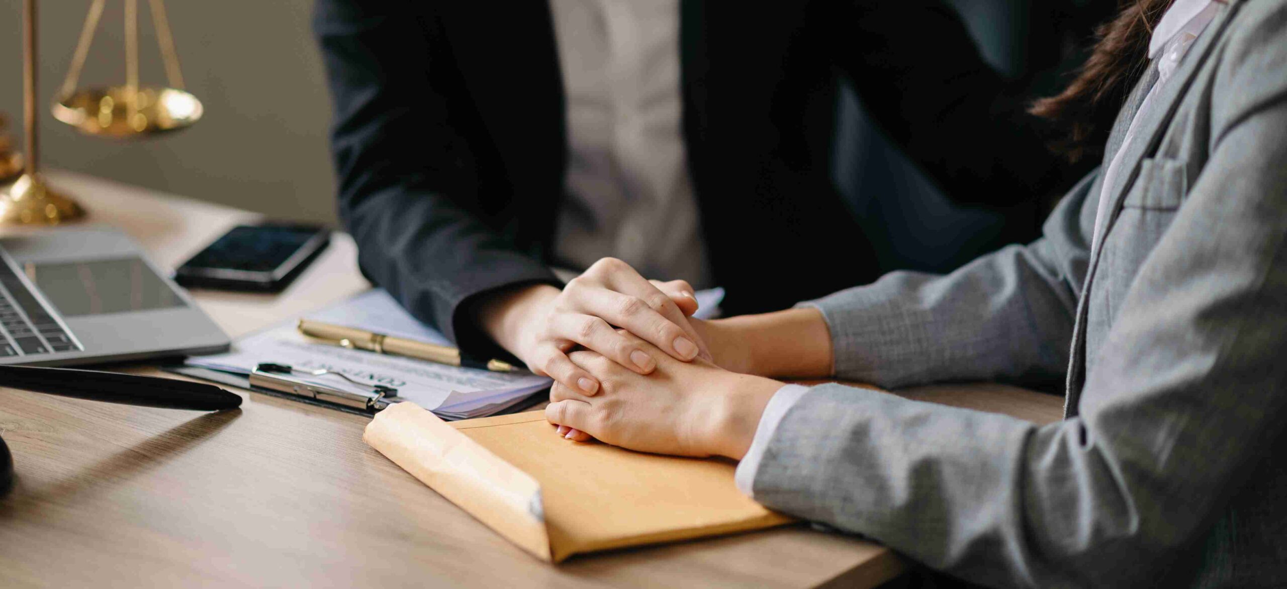 Two people collaborate at a desk, using a laptop and a notebook for Tenant Legal Support discussions.