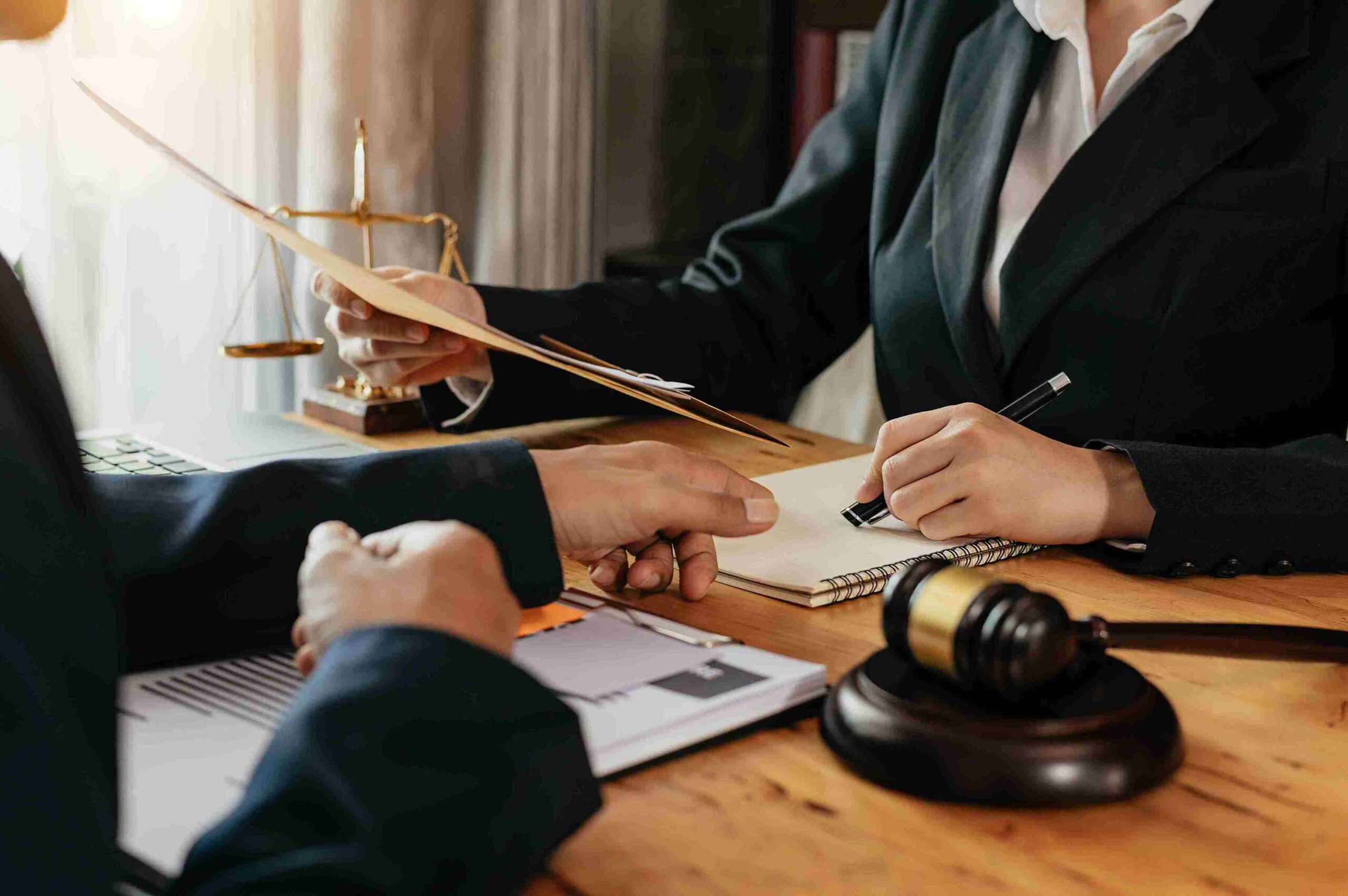 A lawyer and client discuss financial settlement disputes at a desk with a gavel in a family law context.