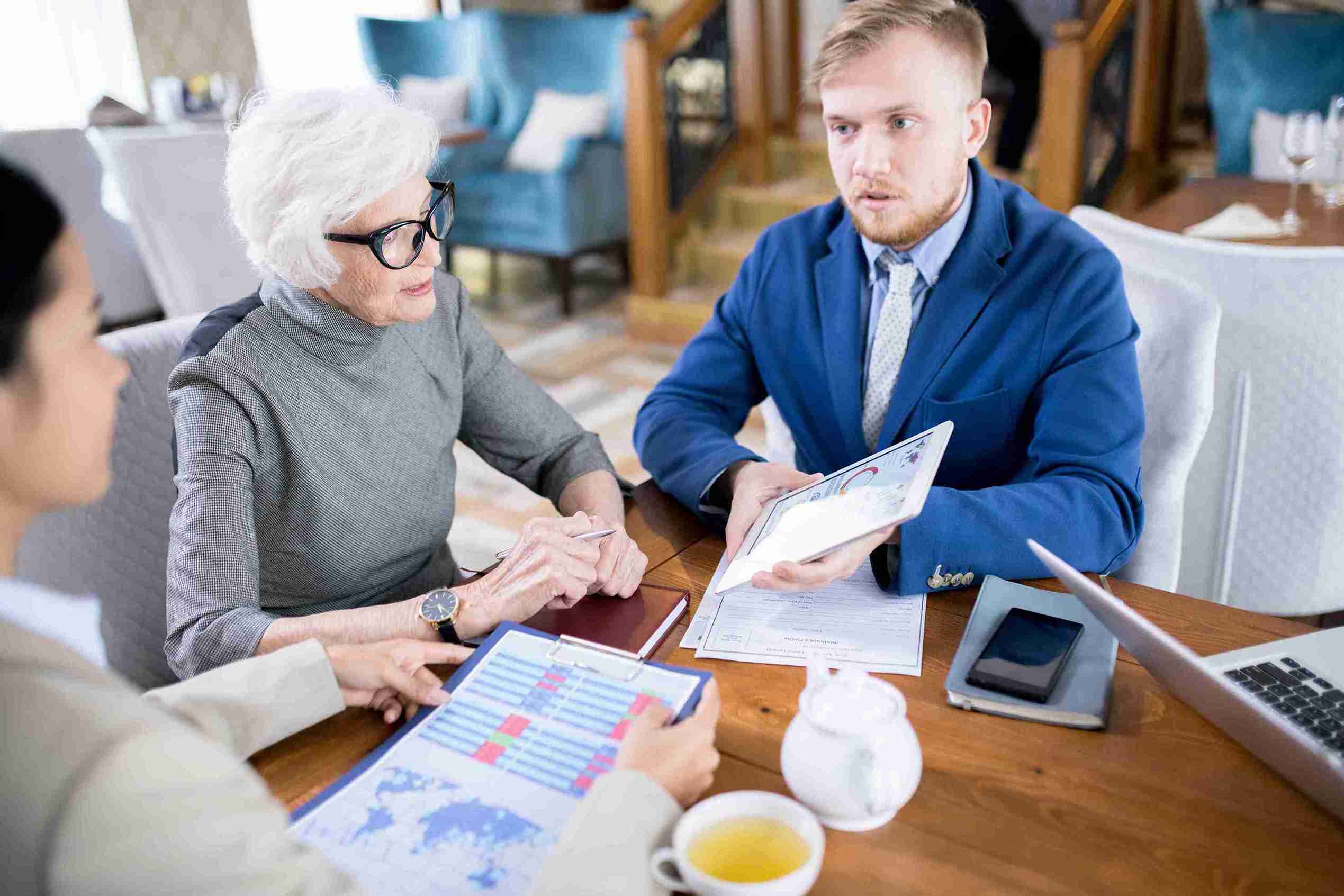 A man and woman sit at a table with a laptop, discussing Sole Representative Visa Expert legal support for UK business growth.