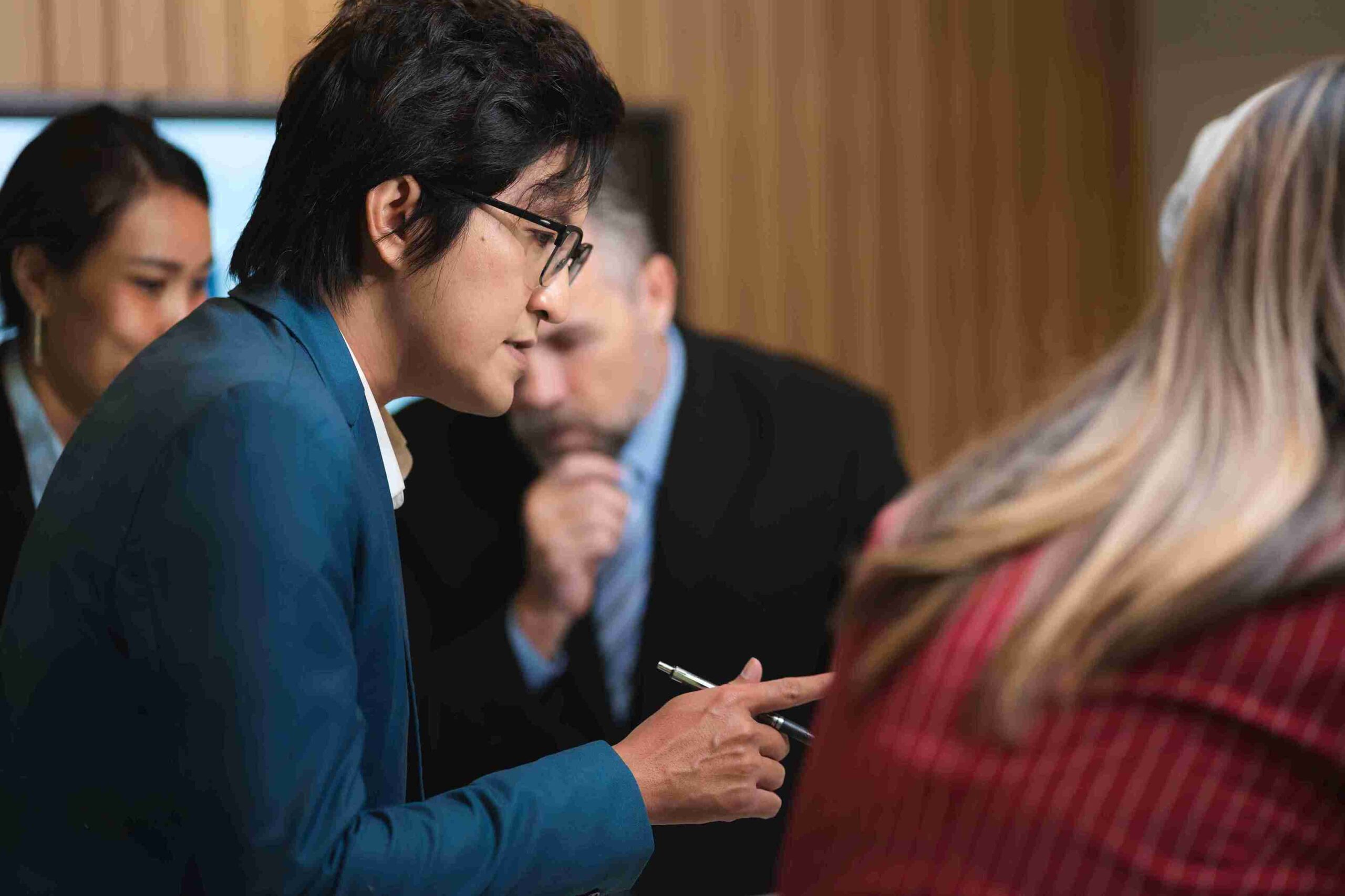 A man and woman in business attire engage in conversation, sharing ideas in a professional setting.