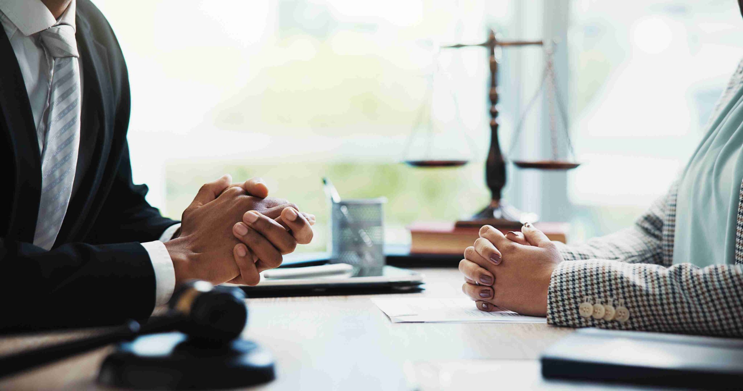Two people discussing a financial settlement after divorce with a lawyer at a table.