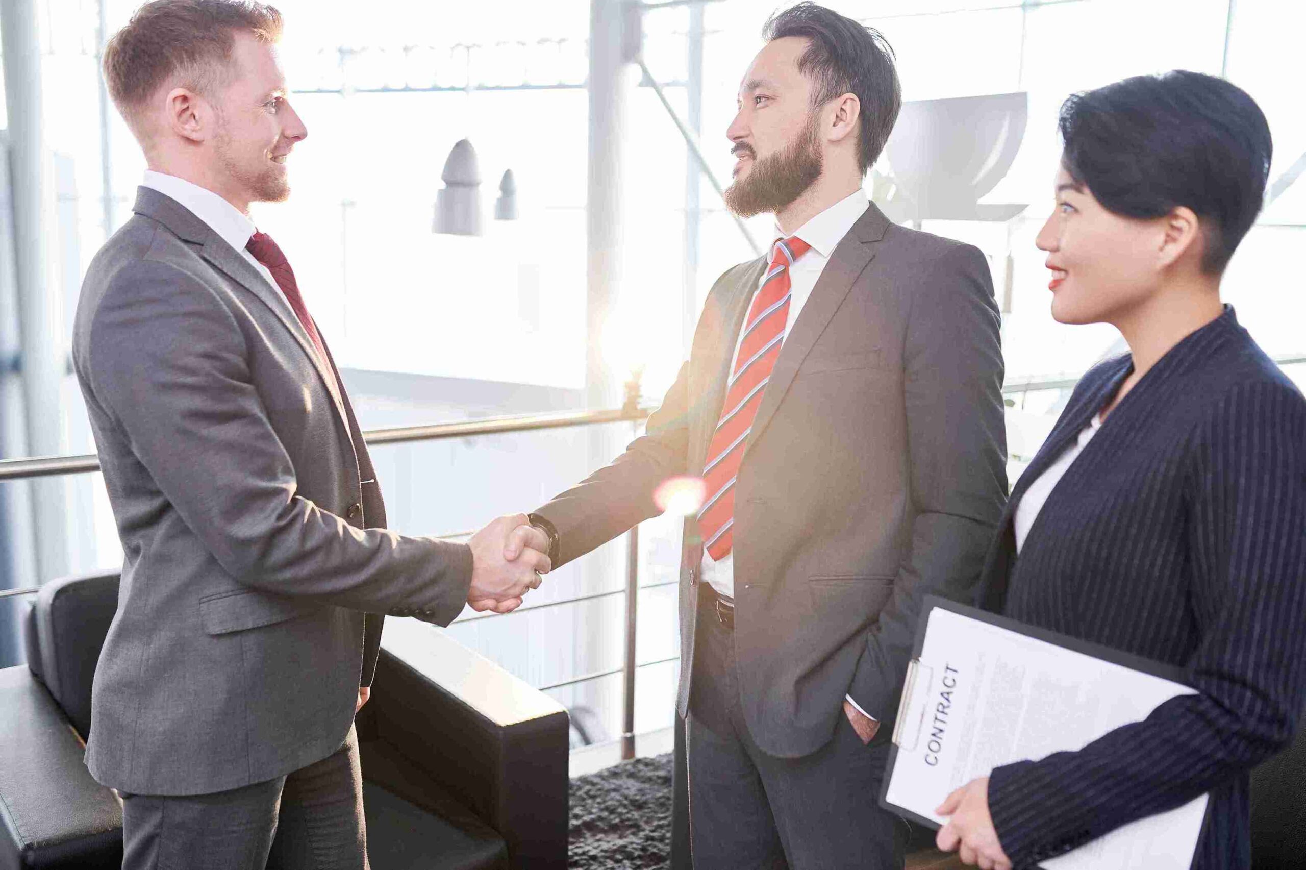 Two business people shaking hands in an office, symbolizing independent business ownership