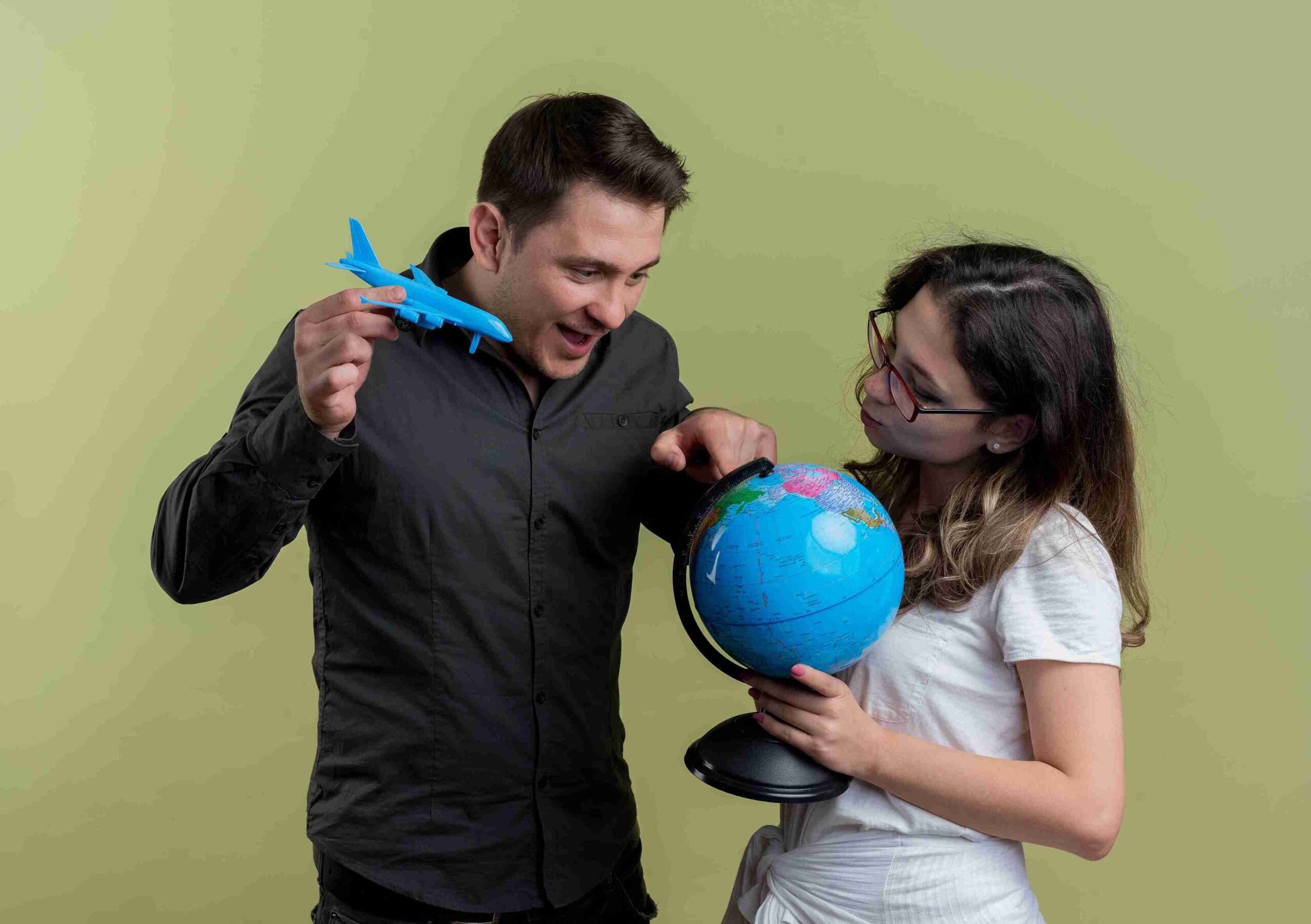 A man and woman hold a globe and a plane, symbolizing travel and the visa process