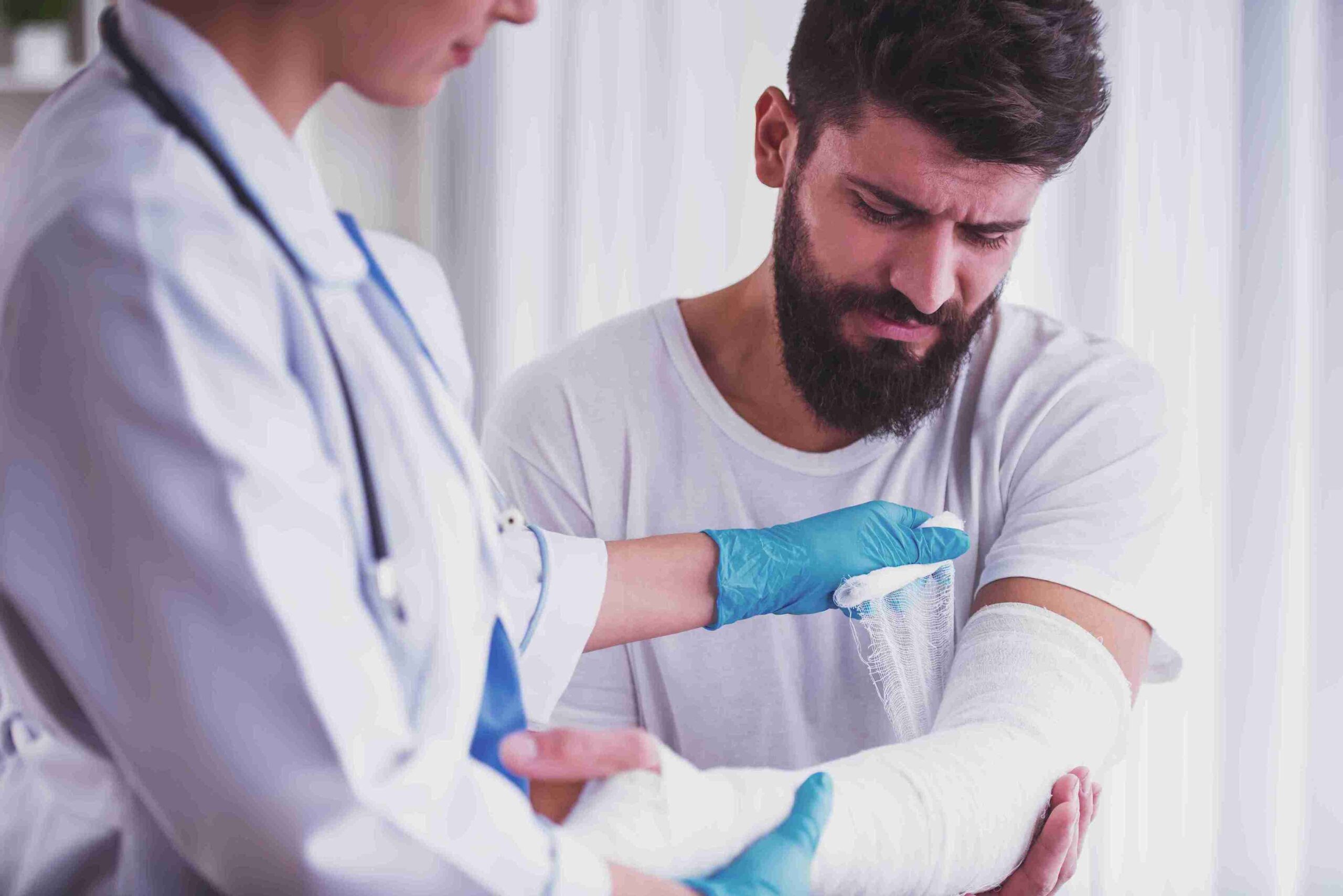 A man with a cast on his arm is examined by a doctor, highlighting legal support for medical injuries.