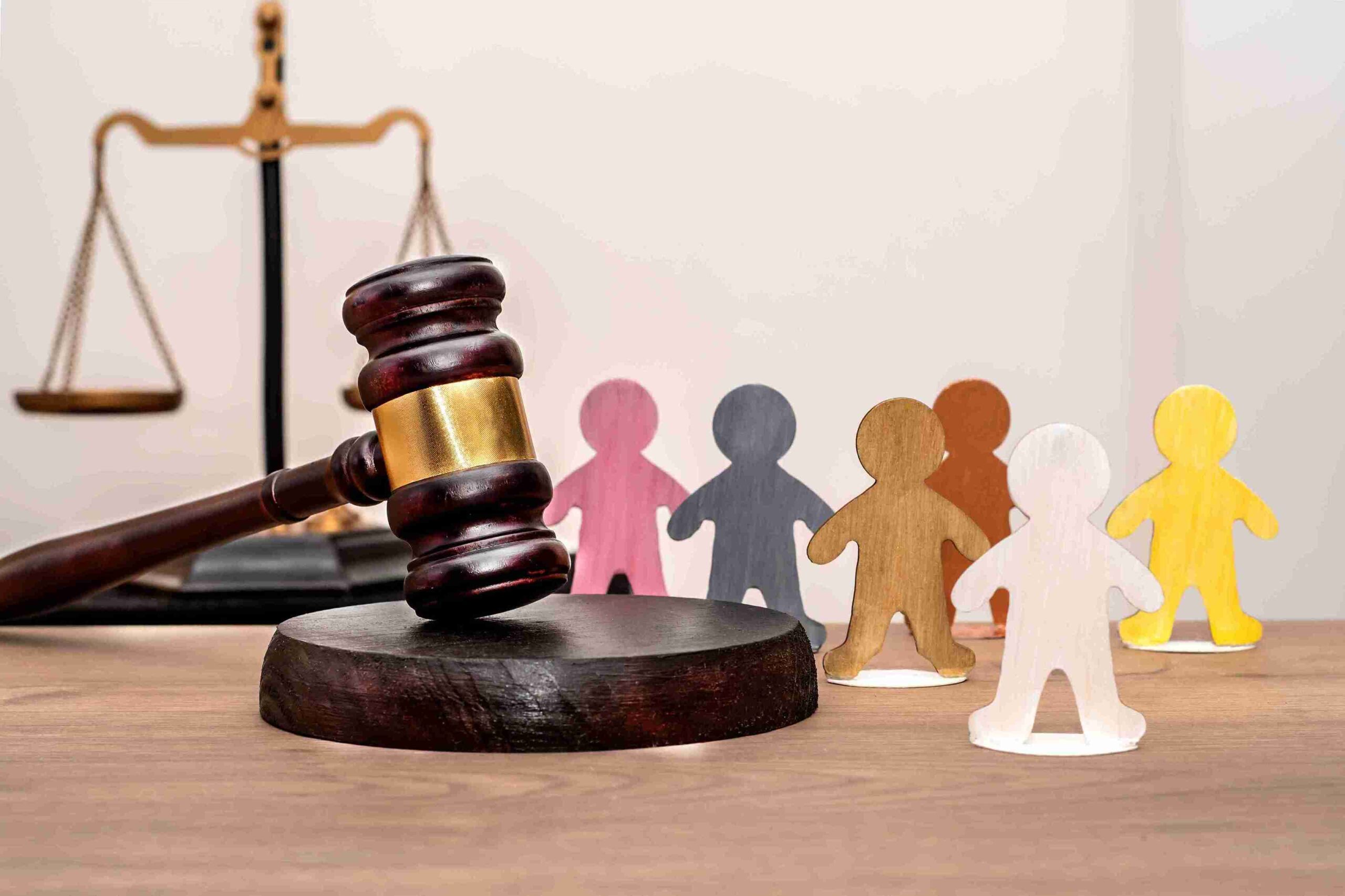 Judge's gavel on a wooden table surrounded by wooden figures, symbolizing the concept of injunctions in law