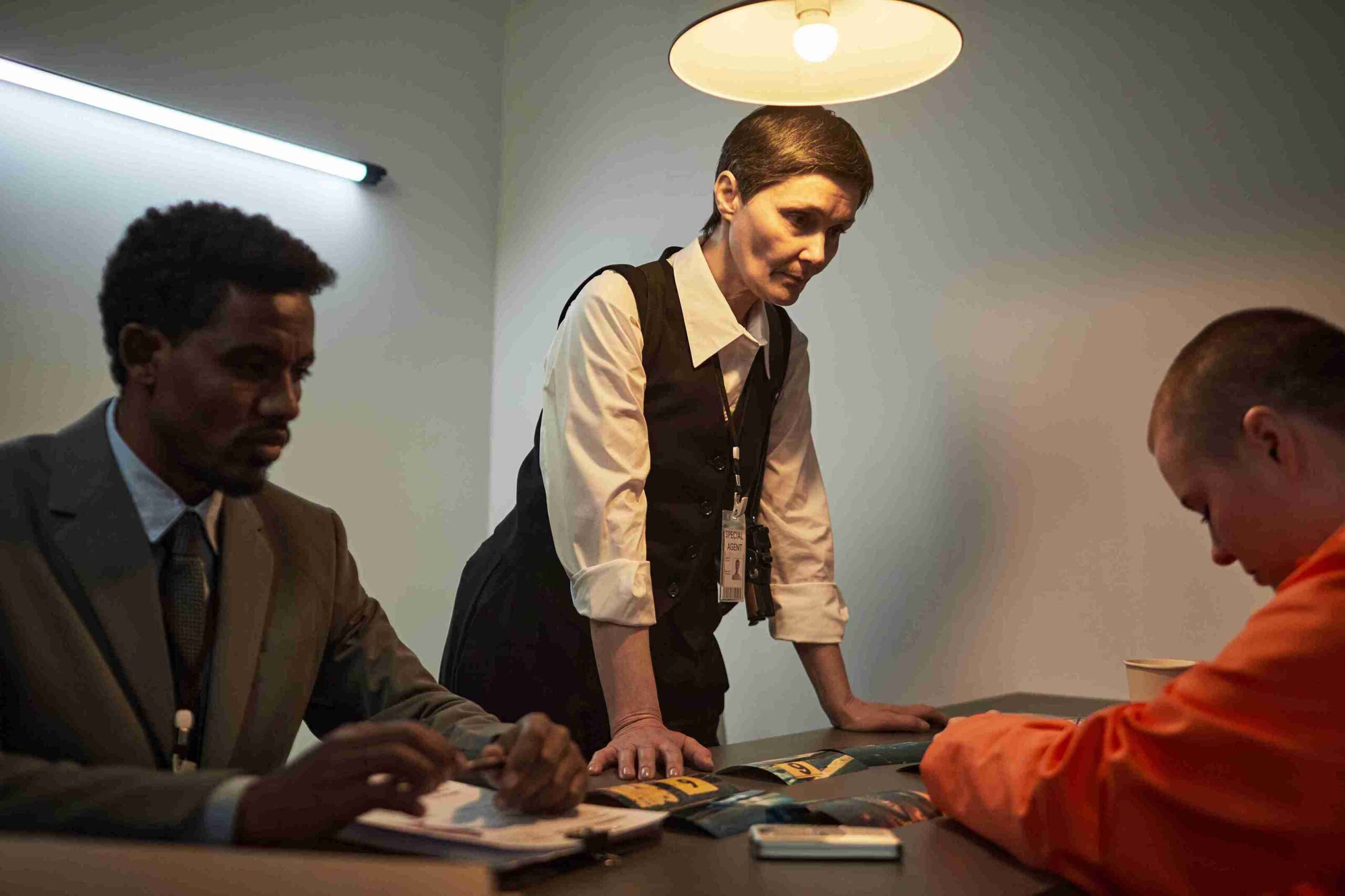A man and woman collaborate in a modern office, surrounded by desks and computers, engaged in a discussion.