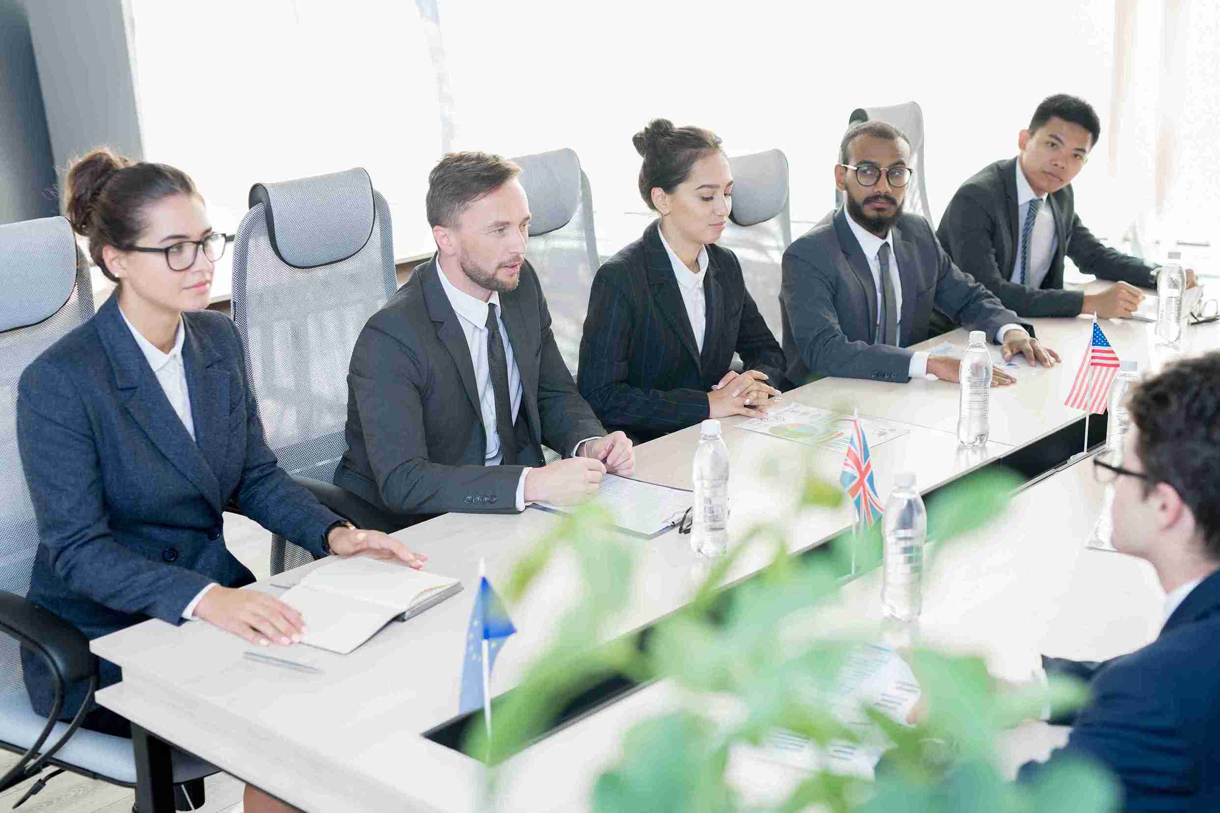 A group of business people discussing at a conference table, focusing on Sole Representative Visa UK eligibility requirements.