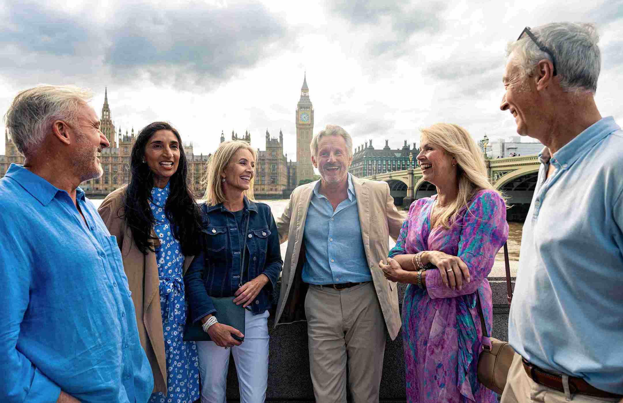 A diverse group of people poses together in front of Big Ben, showcasing the iconic clock tower in London.