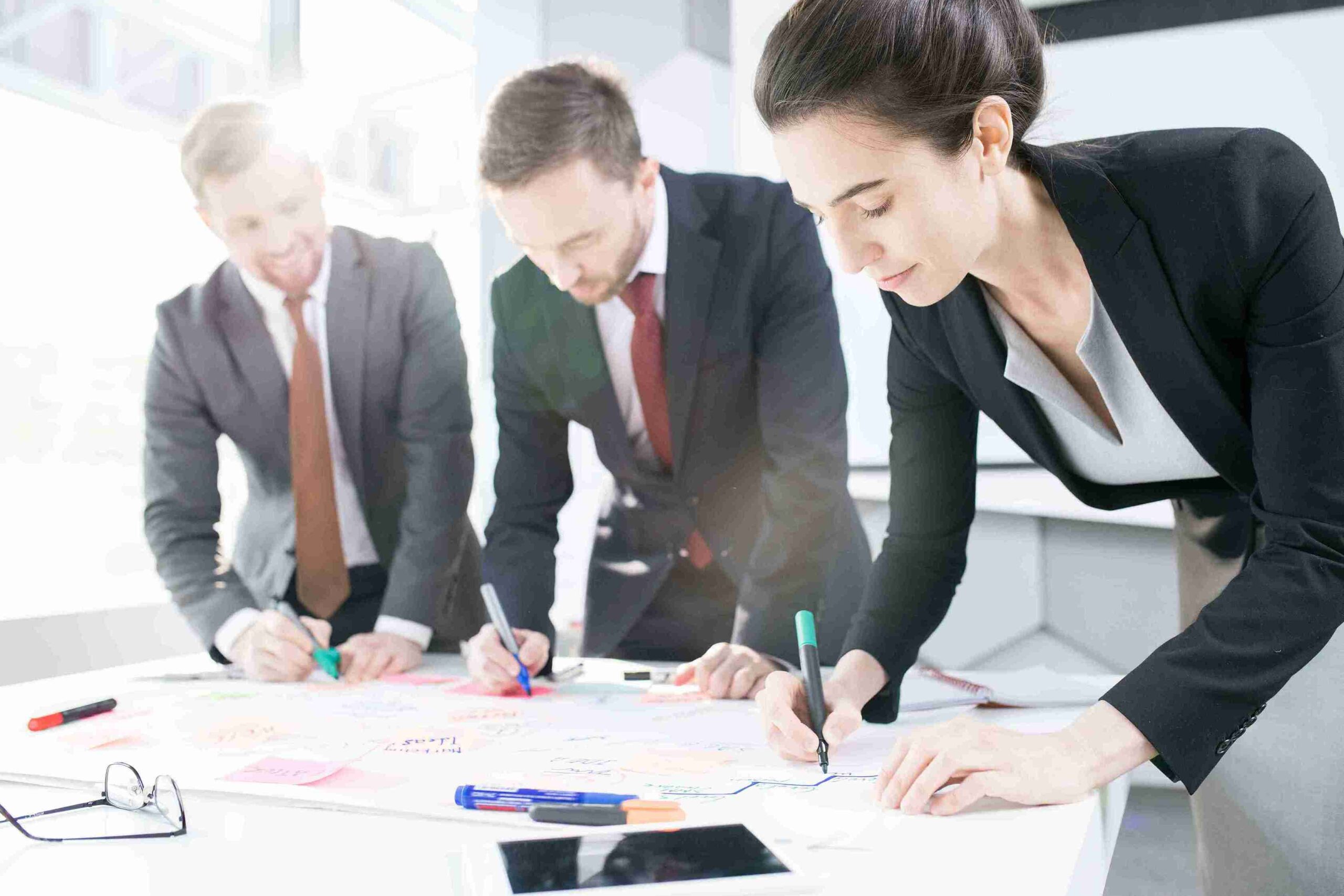 Three business people collaborating on a project related to UK Business Immigration