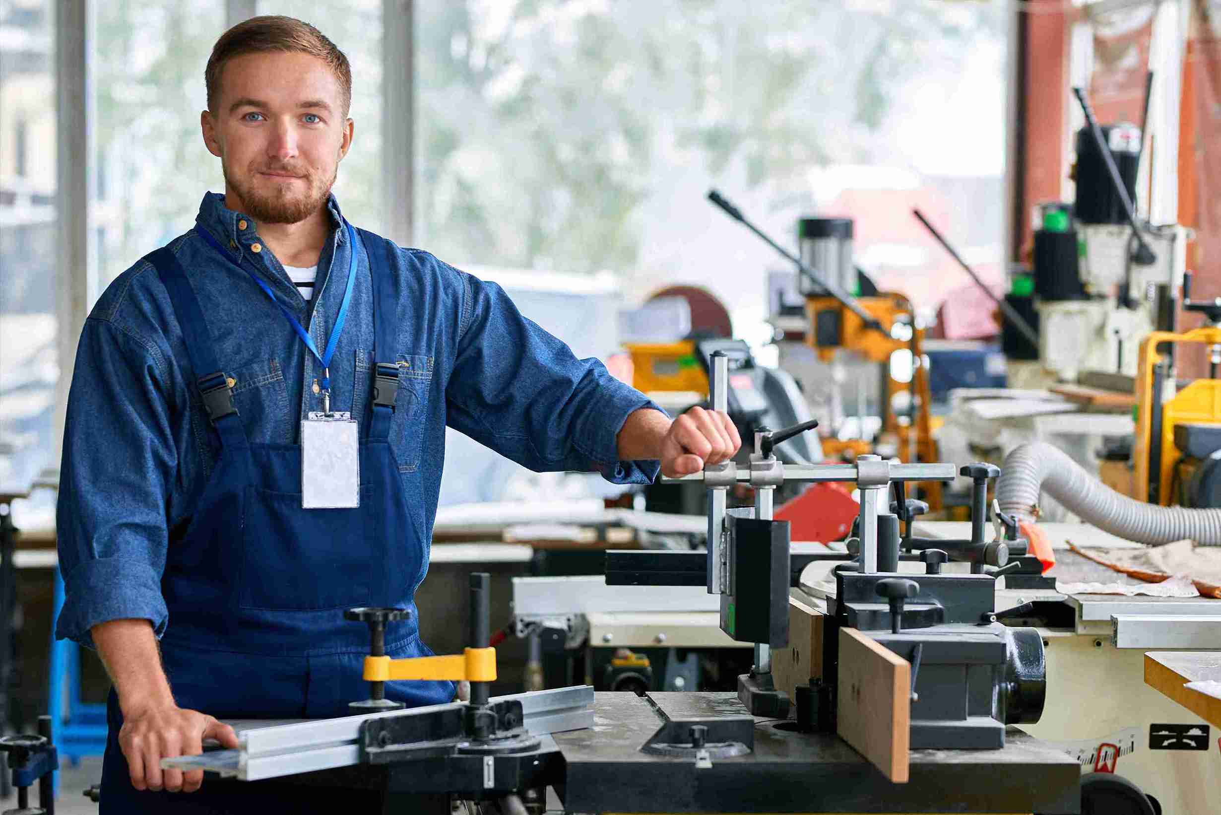 A man works on a machine in an industrial setting, showcasing skills relevant to Self-Sponsorship Skilled Worker programs.