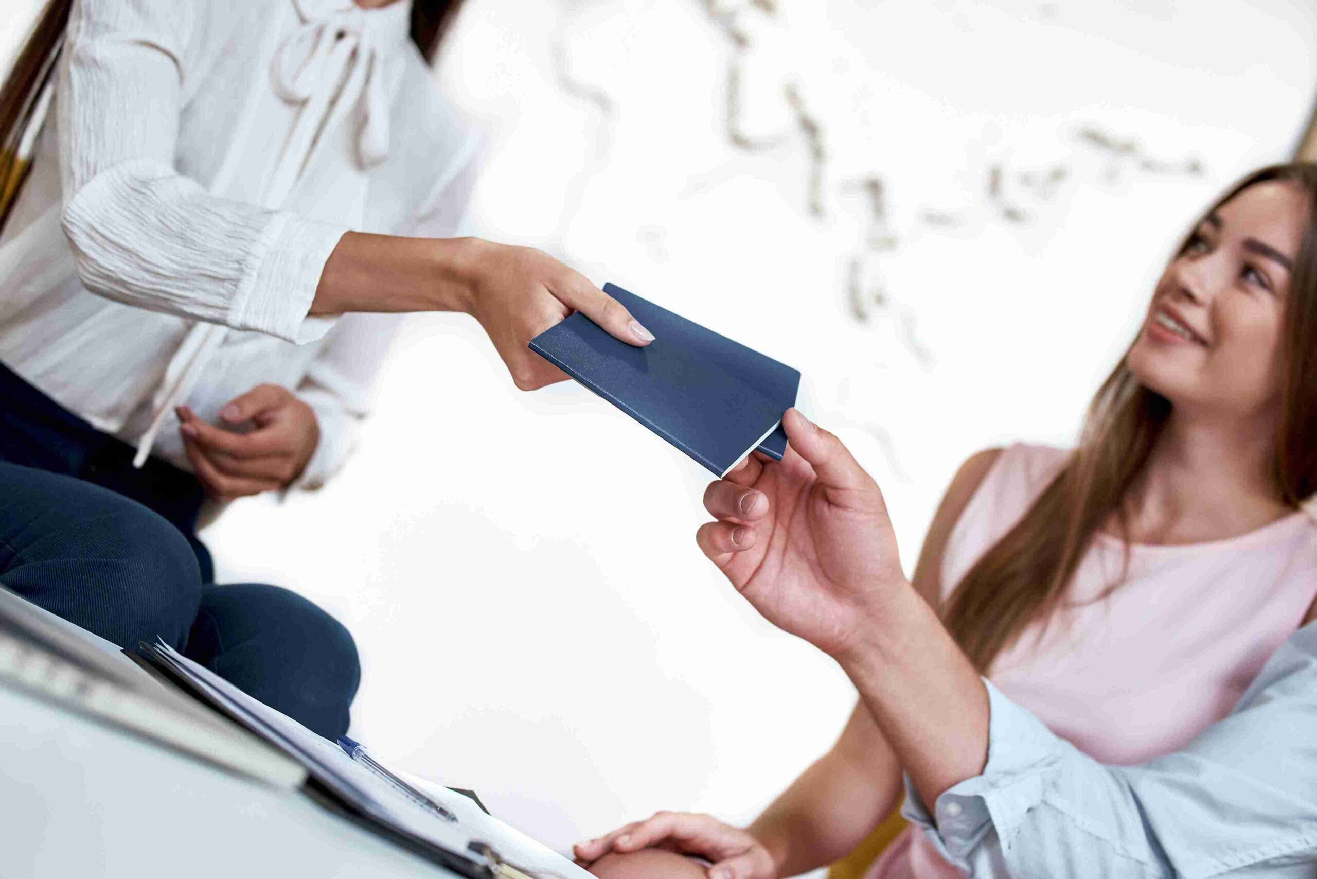 A man and woman hold documents and a passport, appearing ready for travel or an important meeting.