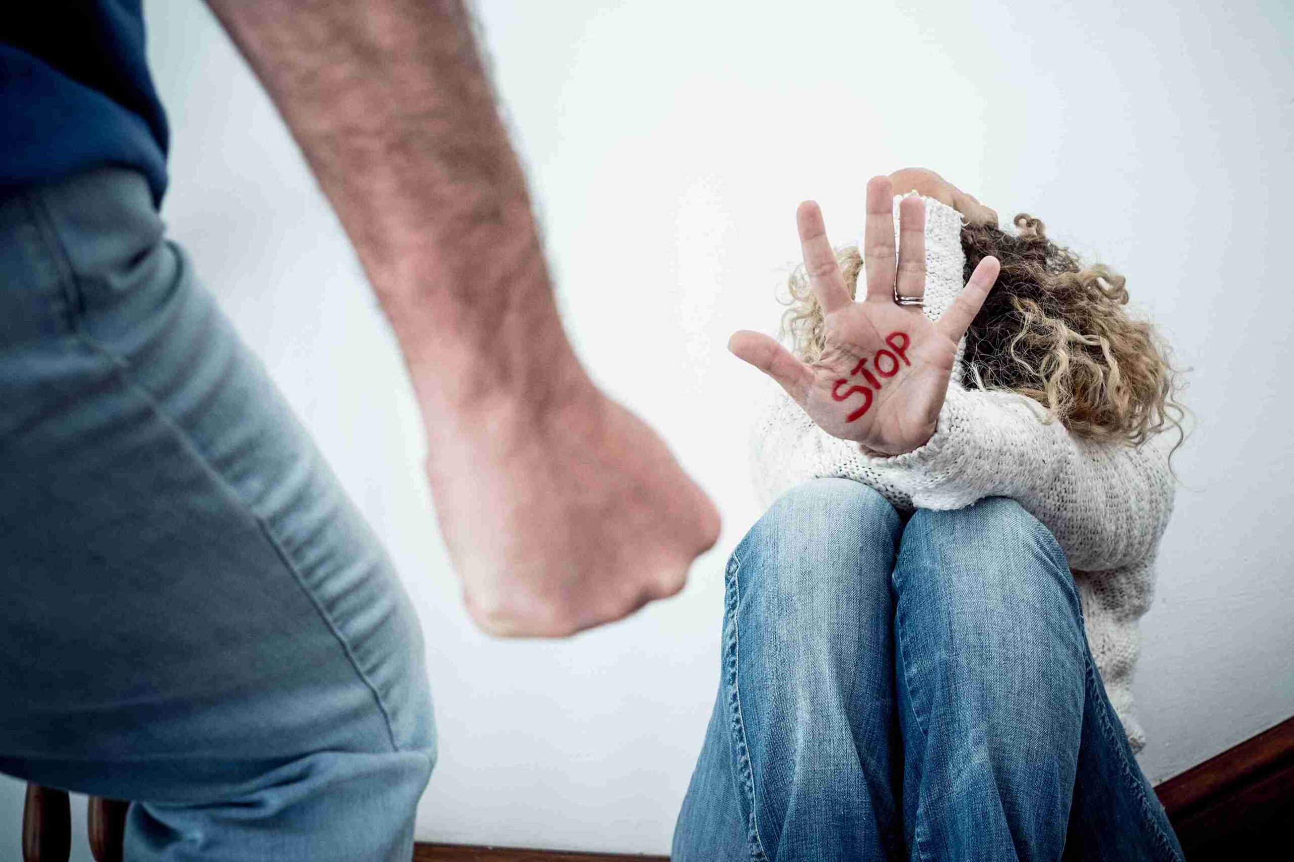 A woman covers her face with her hands, appearing shocked, as a man stands behind her, observing the scene.